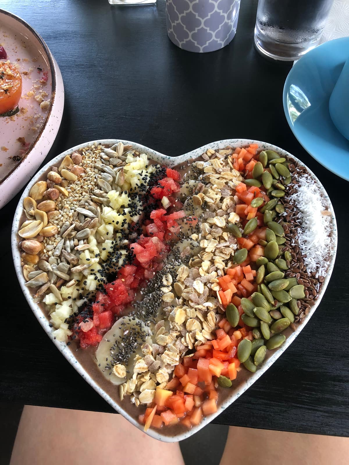 Bowl mit Müesli, Kernen, Wassermelone und Papaya, in Streifen angerichtet